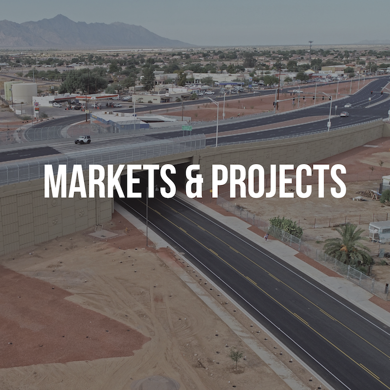 A faded picture of a freeway overpass in the background with white text on top that says “MARKETS & PROJECTS”.