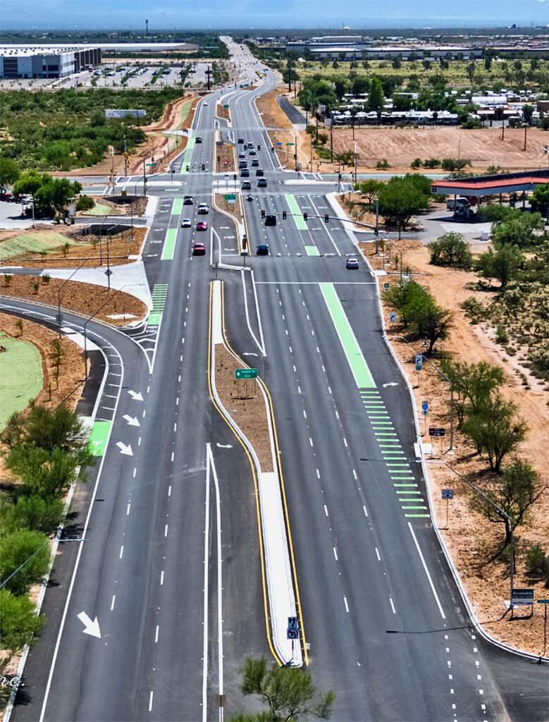 An aerial photo of a vehicle intersection with separated turn lanes and green bicycle lanes.
